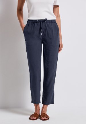 Pantalones ligeros de color azul marino con un acabado texturizado, cintura elástica y cordón. Cuenta con dos bolsillos delanteros y un corte relajado que se ajusta en los tobillos.