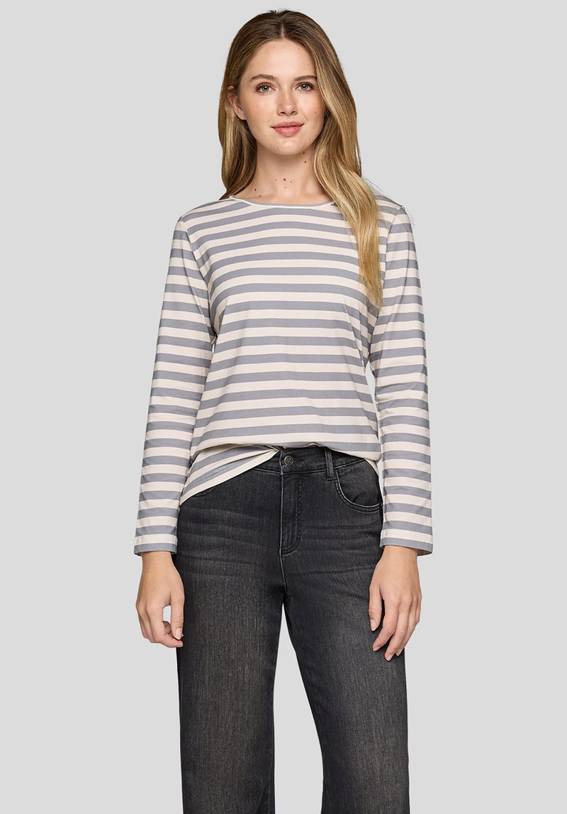 Langärmliges, hellgraues gestreiftes Hemd mit cremefarbenen horizontalen Streifen. Weicher Stoff mit lockerem Schnitt, kombiniert mit dunklen Jeans.