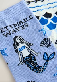 Șosete bleu cu un desen de sirenă și textul „HAIDEM SĂ FACEM VALURI,” înconjurat de modele cu cochilii și stele de mare. Material moale tricotat.