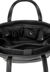 Sac à main en cuir noir ouvert montrant plusieurs compartiments intérieurs, une poche zippée, des emplacements élastiques et deux poignées.