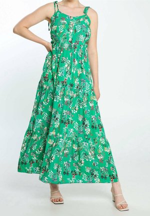 Robe maxi florale verte avec des bretelles spaghetti, un design en couches, des détails de bouton et un tissu léger comportant divers motifs floraux.