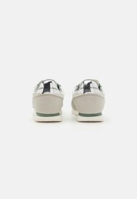 Graue Wildledersneaker mit metallischen Akzenten, grünen Details und einer gebogenen Sohle. Verfügt über eine Markenkennzeichnung an der Ferse und ein strukturiertes Obermaterial.