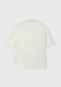 Camicia a maniche corte con colletto realizzata in un tessuto leggero e testurizzato di colore avorio, caratterizzata da un orlo dritto e dettagli minimali.