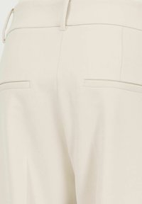 Beige tailored trousers featuring a smooth fabric, straight legs, and two back pockets with flat closures. Minimalist design with a clean silhouette.