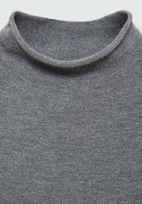 Sivý pletený sveter s jemnou, rebrovanou textúrou a zaobleným výstrihom. Materiál sa zdá byť ľahký a priedušný.