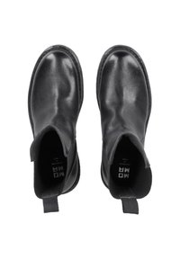 Black leather ankle boots with elastic side panels and pull tabs. Smooth texture, round toe, stitched detailing along the sole.