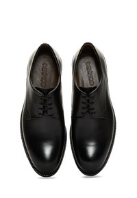 Zapatos de vestir de cuero negro con un acabado liso, punta redonda, diseño con cordones y suela texturizada en contraste. "DERMOD" grabado en el interior.