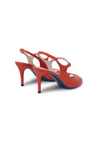 Dei tacchi slingback rossi in pelle con design a punta scoperta, dettagli blu, tacco sottile e cinturino regolabile con fibbia. Texture liscia e finitura lucida.