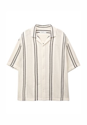 Chemise à manches courtes, boutonnée, en crème avec des rayures verticales noires ; présente un tissu léger et texturé ainsi qu'un col classique.