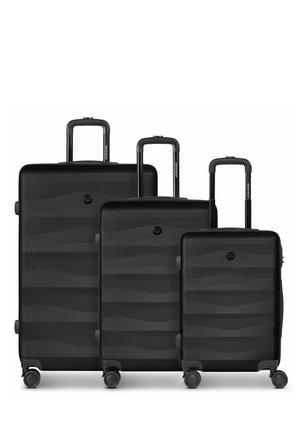Drie zwarte koffers met harde schaal in kleine, middelgrote en grote maat, elk met uitgeschoven uitschuifbare handgrepen en vier zwenkwieltjes.