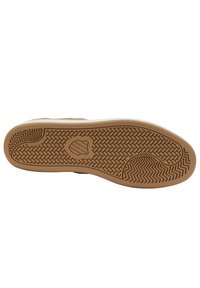 Kengän pohja, jossa on ruskea kumipohja, jossa on herringbone- ja koripunoskuvioita sekä keskellä oleva kilpimerkki.