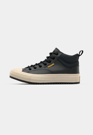 Schwarzer High-Top-Sneaker aus Leder, mit einer cremefarbenen Gummikappe und Plateausohle, schwarzen Schnürsenkeln und einer Zuglasche.