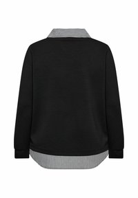 Camicetta nera a maniche lunghe con un look a strati, caratterizzata da un colletto e un orlo a righe bianche e nere, mostrata da dietro.