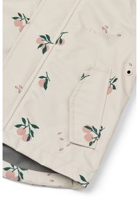 Lichtbeige regenjack met een glanzende afwerking, voorzien van een bloemenpatroon met roze vruchten en groene bladeren. Inclusief een voorkantzak.