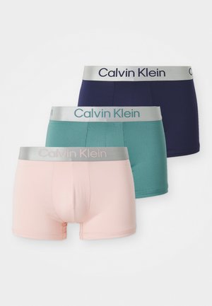 Drie paar Calvin Klein boxershorts in navy, teal en lichtroze. Elk paar heeft een zachte elastische tailleband met de merknaam.