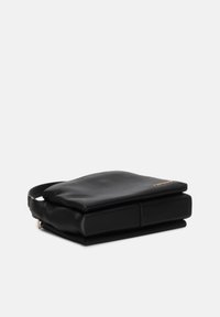 Borsa in pelle nera con una finitura texturizzata, forma rettangolare e una tracolla regolabile. Presenta una parte superiore liscia e un particolare di branding discreto.