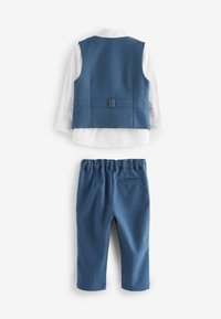 Gilet texturé bleu avec boucle réglable, chemise blanche en dessous, et pantalon bleu à taille élastique assorti avec poche arrière.