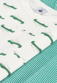 Two T-shirts: one white with green alligator patterns, and one green striped design. Both made of soft cotton with a comfortable fit.