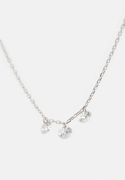 Sidabrinė grandinėlė su trimis skaidriais apvaliais kristalais, kiekvienas pakabintas ant grandinėlės, atspindintis šviesą ir suteikiantis papildomą spindesį.