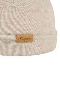 Beige knit beanie with a ribbed texture and a folded brim. Features a brown leather tag with the word "Sterntaler."
