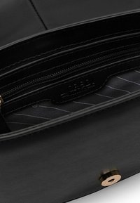 Schwarze Lederhandtasche mit Innentasche mit Reißverschluss, gestreifter Stoffauskleidung und goldenen Beschlägen.