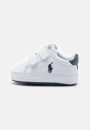 Weißer Kleinkind-Sneaker mit schwarzem Polo-Logo, zwei Klettverschlüssen und schwarzem Fersenlasche auf schlichtem weißem Hintergrund.