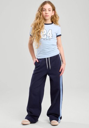 Light blue fitted t-shirt with navy accents and printed number "24," paired with navy wide-leg pants featuring a light blue side stripe.