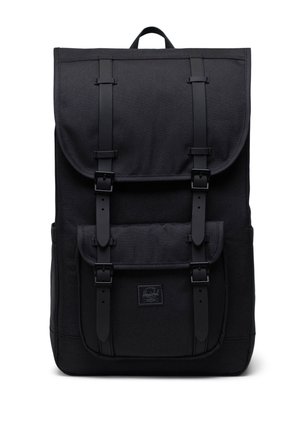 Čierny obdĺžnikový batoh s horným klopou a predným vreckom zabezpečeným dvoma vertikálnymi popruhmi s prackami a horným držadlom.