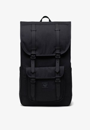 Zaino rettangolare nero con un lembo superiore e tasca frontale fissata da due cinghie verticali con fibbie e una maniglia superiore.