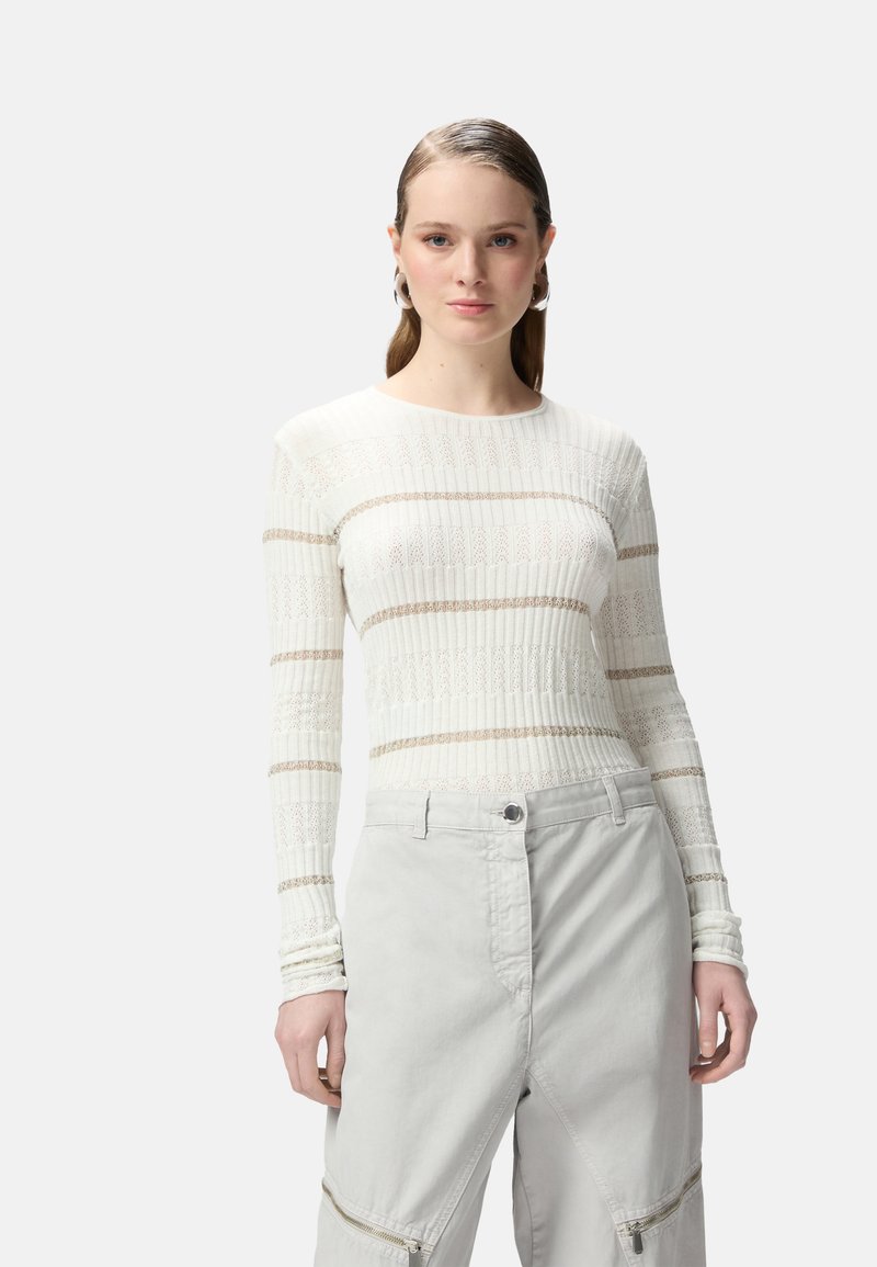 Maglietta leggera a maniche lunghe a righe ribattute in bianco con sottili strisce beige. Abbinata a pantaloni grigi chiari con zip e chiusura a bottone.