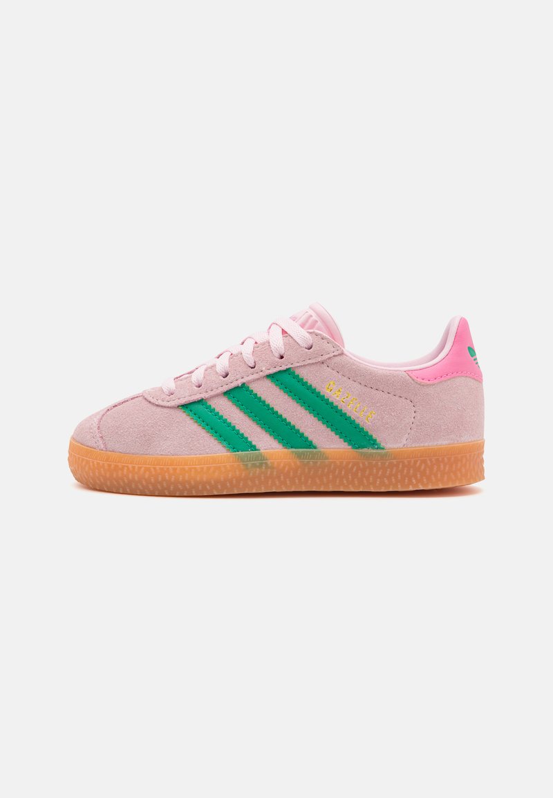 Rozā zamšāda sporta apavi ar zaļām svītrām, gumijas zole un plakani aizdari. Iezīmēts ar mīkstu apkaklīti un zīmolu sānos.