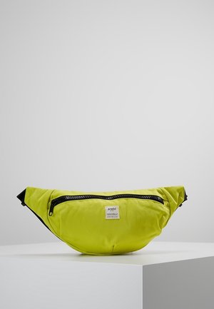 Sac banane de marque Anello vert vif avec fermeture éclair noire et sangles réglables, posé sur un piédestal blanc sur un fond uni.