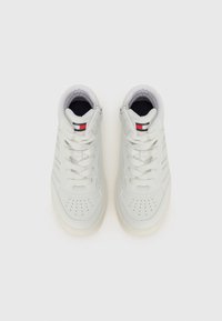 Hvite høyre sneaks med en glat skinnfinish, med perforerte tåkapper, snørebåndsdesign og en liten logo i rødt og blått.