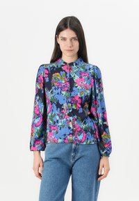 Blouse florale colorée avec un fond bleu, présentant des motifs roses, verts et oranges, fermeture à boutons et manches longues bouffantes.