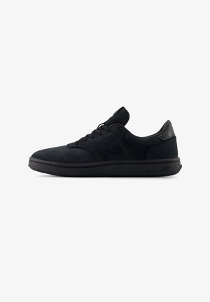 Baskets de sport basses noires avec lacets à l'avant, finition lisse et semelle rembourrée, montrées en profil latéral sur fond blanc.