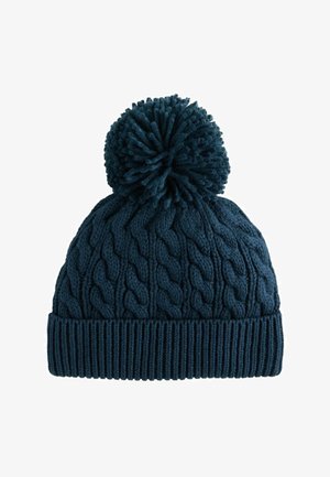 Mørkeblå strikket vinterhue med kabelmønster, foldet kant og stor pompon på toppen.
