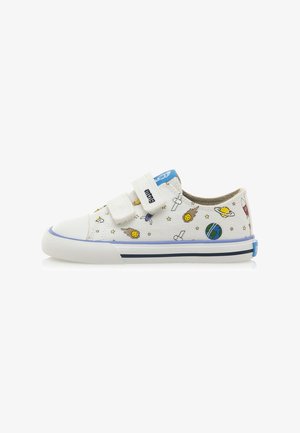 Baskets en toile blanches avec des motifs colorés sur le thème de l'espace, bandes Velcro, accents bleus et semelle en caoutchouc avec un logo bleu sur le talon.