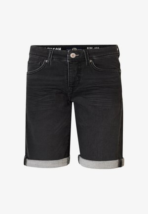 Maglietta azzurro chiaro con un design testurizzato, abbinata a pantaloncini di jeans neri con orli risvoltati e sneaker bianche con calze grigie.