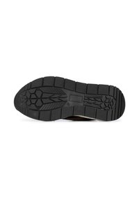 Semelle de chaussure en caoutchouc noir avec surface texturée présentant des rainures profondes et un motif pour la adhérence et la durabilité.