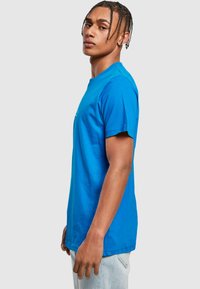 Blå bomulds T-shirt med korte ærmer, rund halsudskæring og en afslappet pasform. Har et enkelt design uden mønstre eller accenter.