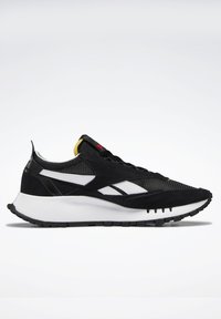 Sorte sneakers med en overdel i mesh og ruskinn, med hvite detaljer, en polstret hvit mellomsåle og en teksturert svart gummisåle.