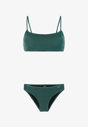 Gebreid donkergroen tweedelig bikiniset met een top met een vierkante halslijn en lage taille broekjes tegen een witte achtergrond.