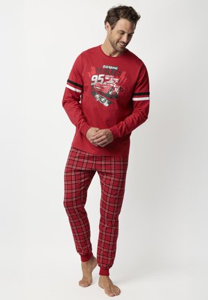 Pijama roja de manga larga con un estampado gráfico de un coche, combinada con pantalones de cuadros rojos con detalles en negro y puños acanalados. Textura de tela suave.