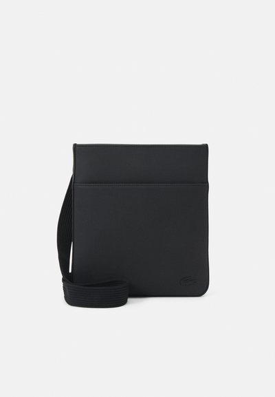 Sac banane noir en tissu texturé, avec un design rectangulaire simple, une sangle réglable et un logo à l'avant.