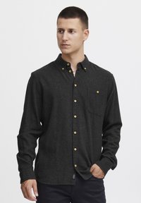 Charcoal flannel shirt with a button-down collar, featuring golden buttons, a chest pocket, and long sleeves. Soft texture and casual fit.