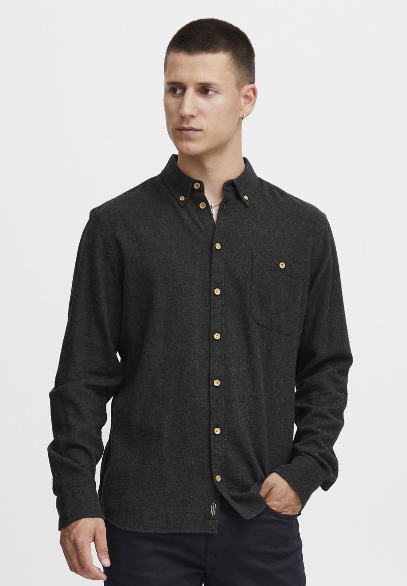Charcoal flannel shirt with a button-down collar, featuring golden buttons, a chest pocket, and long sleeves. Soft texture and casual fit.