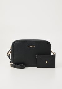 Schwarze Leder-Crossbody-Tasche mit einem goldenen Logo und goldfarbenen Beschlägen. Enthält ein passendes kleines Kartenetui mit Druckverschluss.