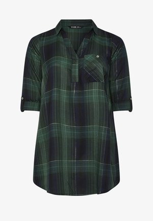 Camicia a quadri verde e blu navy con colletto, maniche arrotolabili e una tasca sul petto. Realizzata in tessuto leggero e testurizzato.