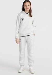 Sudadera y pantalones de chándal gris claro, hechos de una mezcla de algodón, con texto negro: "Mujeres de la Ola". Ajuste cómodo con puños y bajo acanalados.
