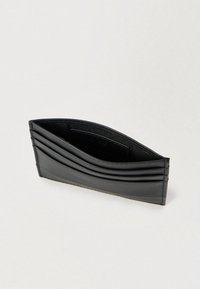 Juodas odinis kortelių dėklas su keliomis kortelių kišenėmis, išlenktu dizainu, lygiu paviršiumi ir subtiliu siuvimu palei kraštus.